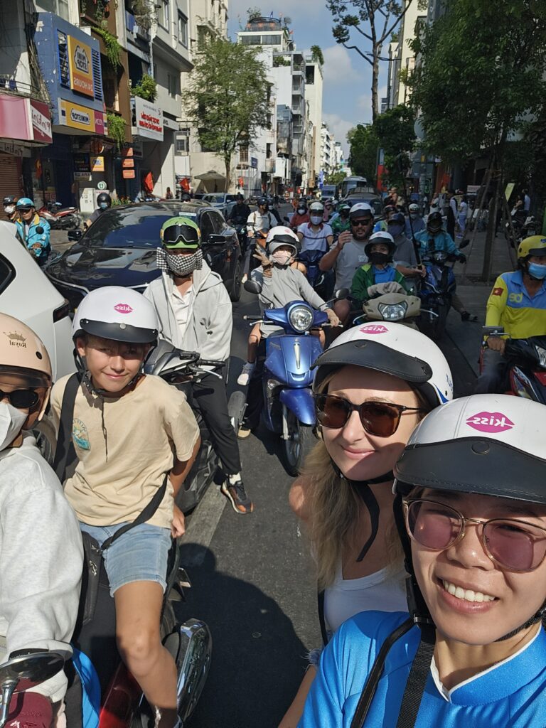 Family taking a guided motorbike tour through the busy streets of Ho Chi Minh City Vietnam with KISSMotorbikeTour