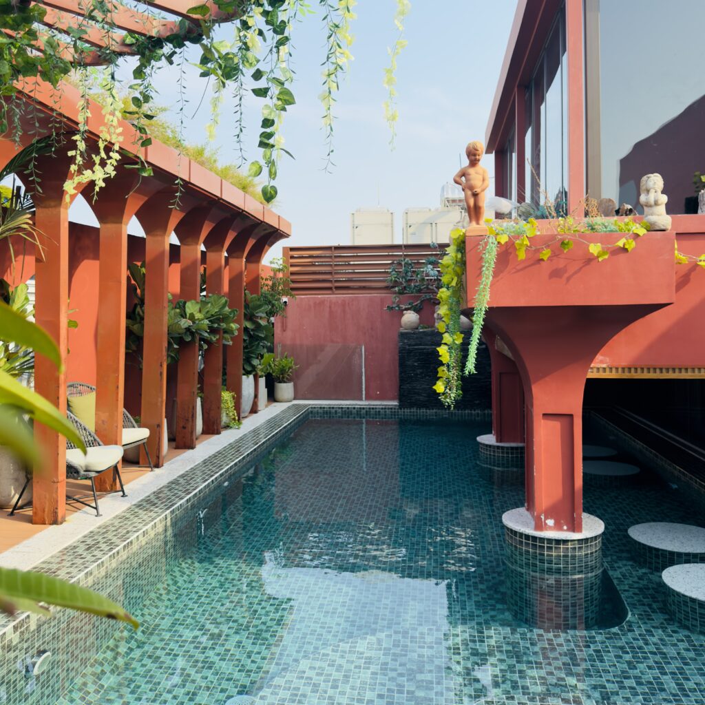 Rooftop swimming pool at Me Saigon Hotel in Ho Chi Minh City Vietnam with turquoise water and red architectural features