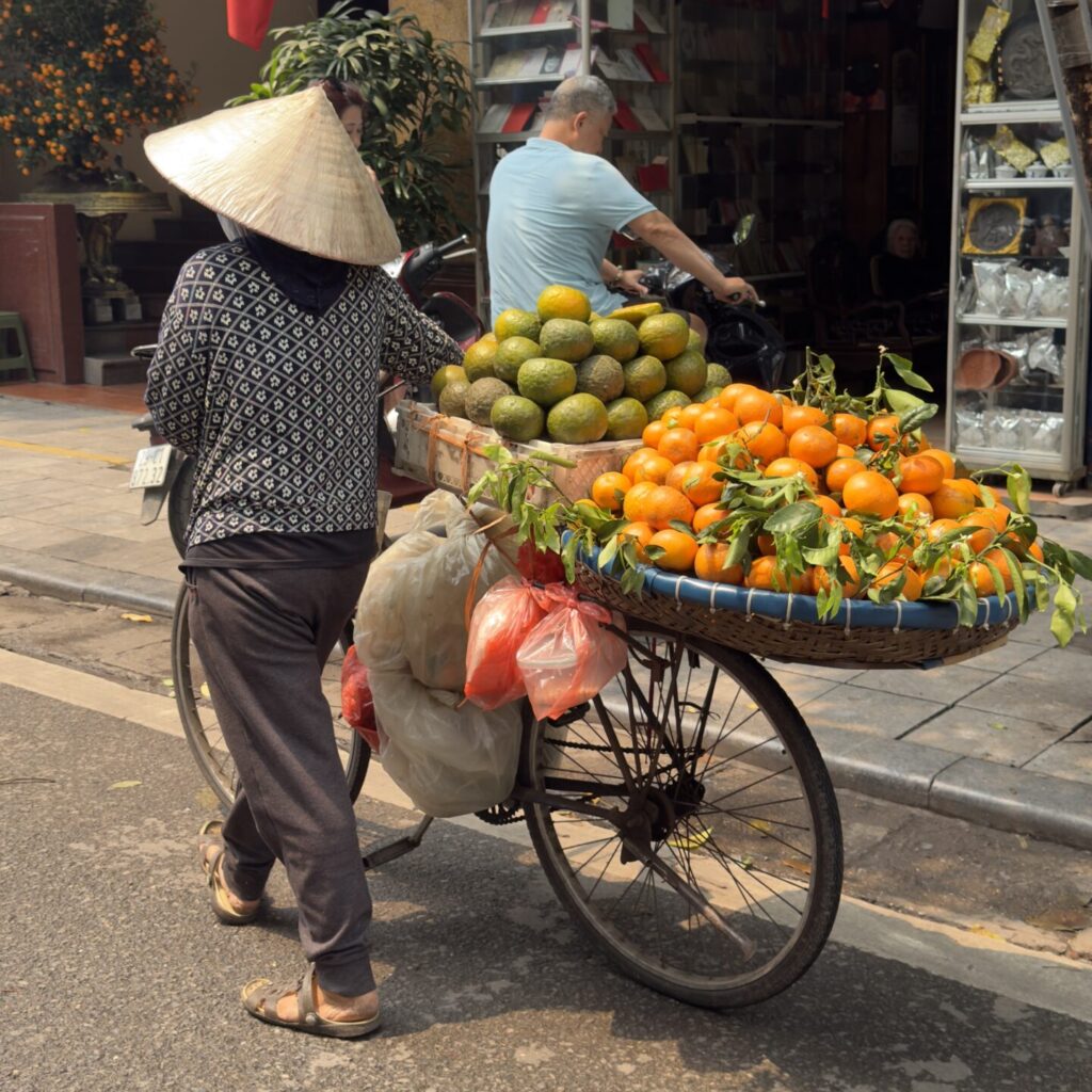 Fruit vendor selling fresh produce on a street in Hanoi, Vietnam