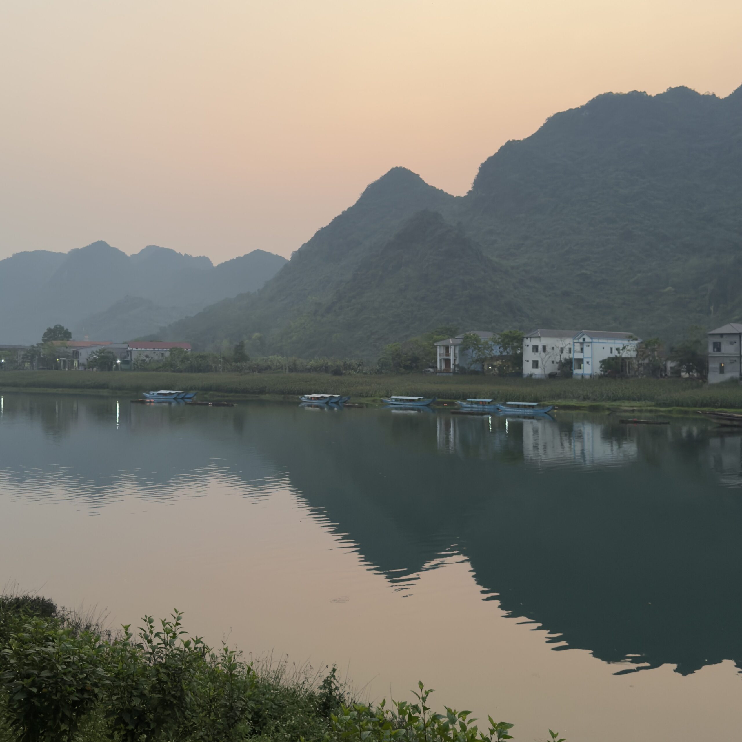 Phong Nha With Kids: Where To Stay, Eat & The Best Things To Do Sunset reflecting on the river with mountain views in Phong Nha, Vietnam