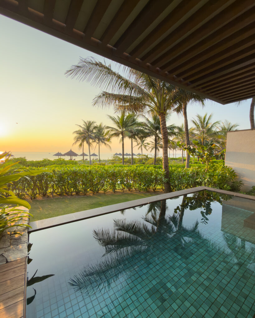 Alma Villa private pool overlooking the beach at sunset, with palm trees, tropical gardens and ocean views at a beachfront villa in Vietnam