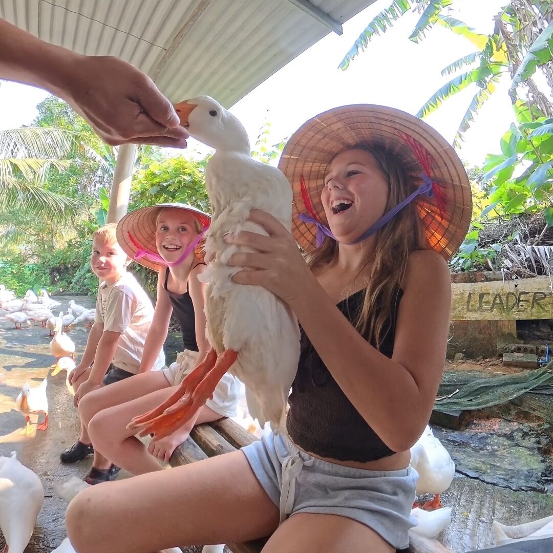 Phong Nha With Kids: Where To Stay, Eat & The Best Things To Do Children feeding a duck at The Duck Stop, Phong Nha, Vietnam