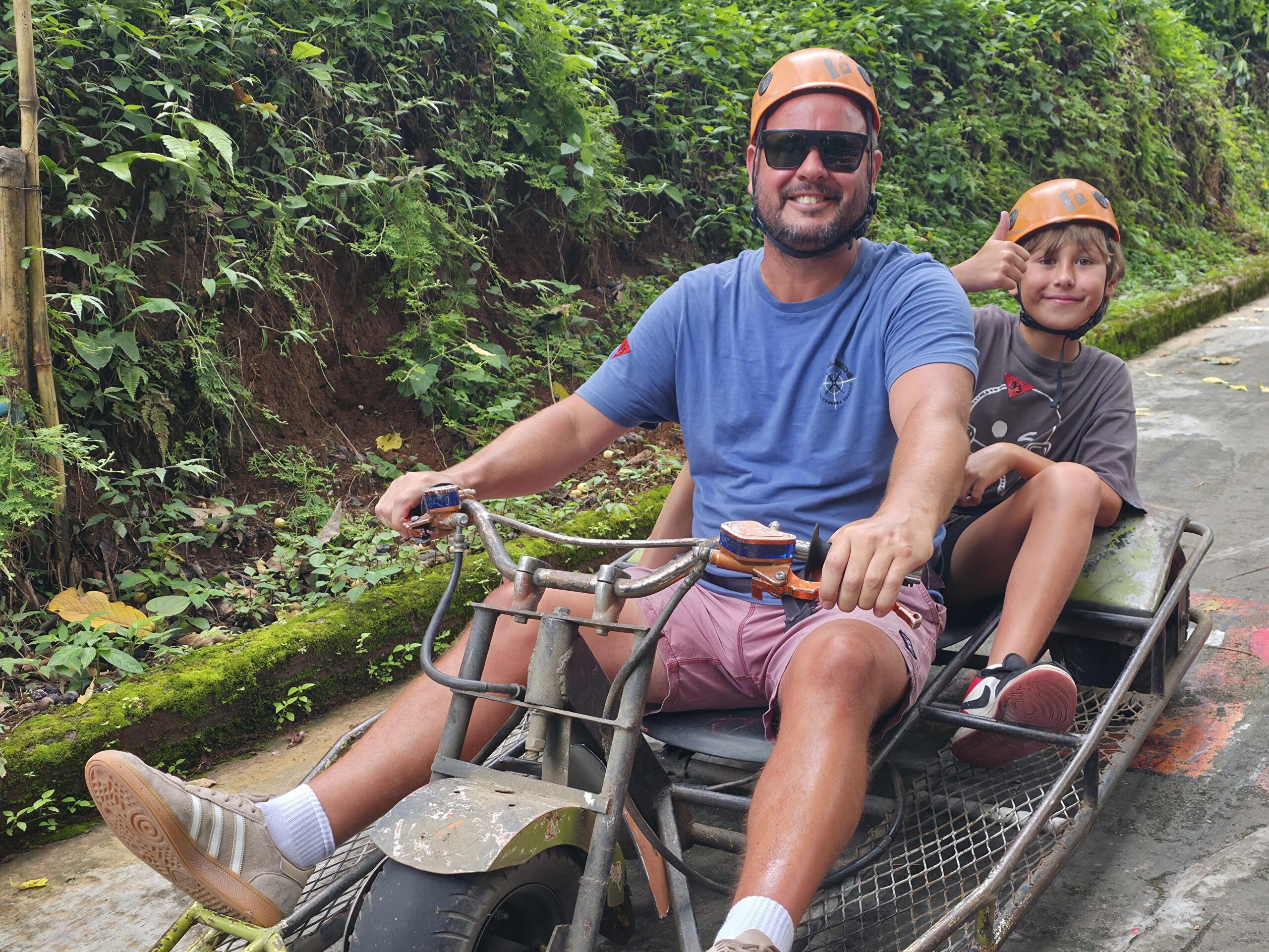 Skyline Adventure Chiang Mai, Thailand, family-friendly outdoor adventure with a parent and child riding a mountain luge through lush tropical forest
